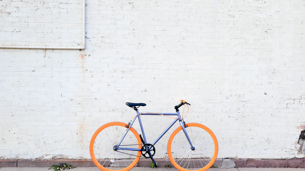 Bike with orange wheels leaning against a white brick wall